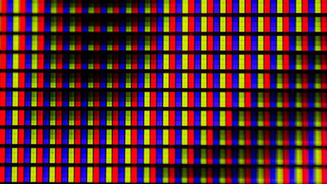 A close-up photograph of blue, red and yellow pixels in a liquid crystal display (LCD) screen. 